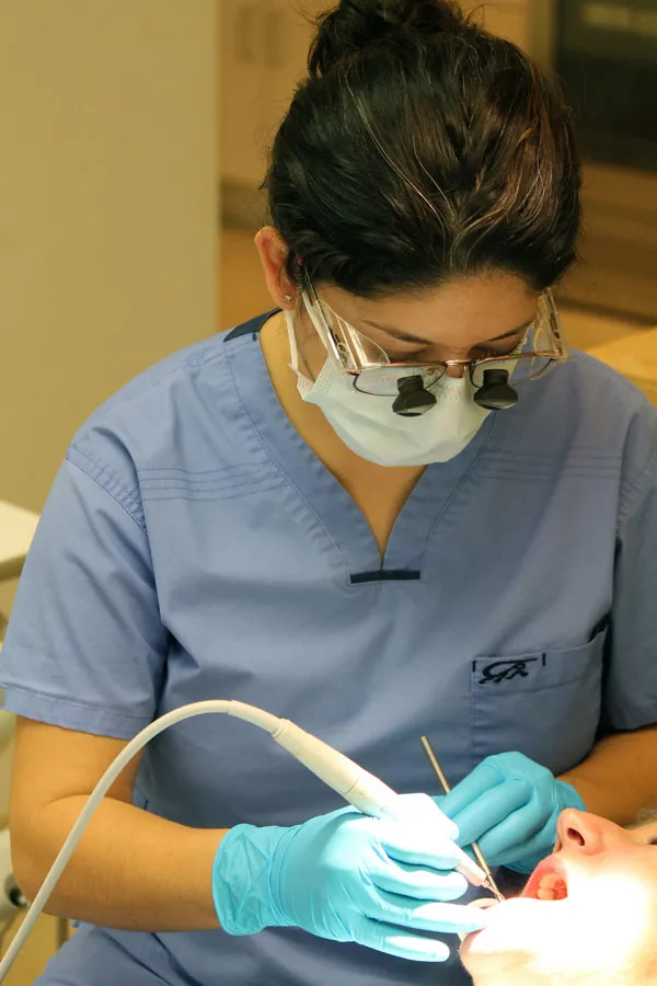 Hygienist with tool in a patient's mouth