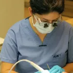 Hygienist with tool in a patient's mouth